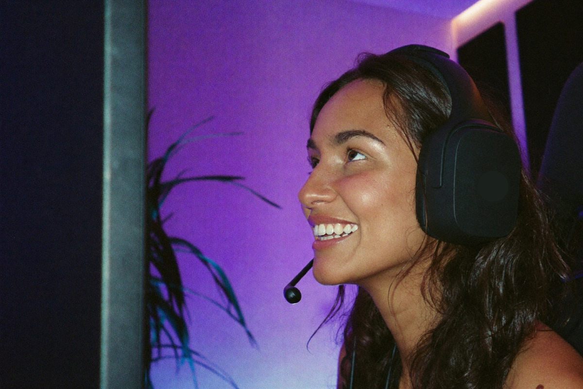 A player in a high-backed chair, lit by shifting ambient light in a modern gaming den.